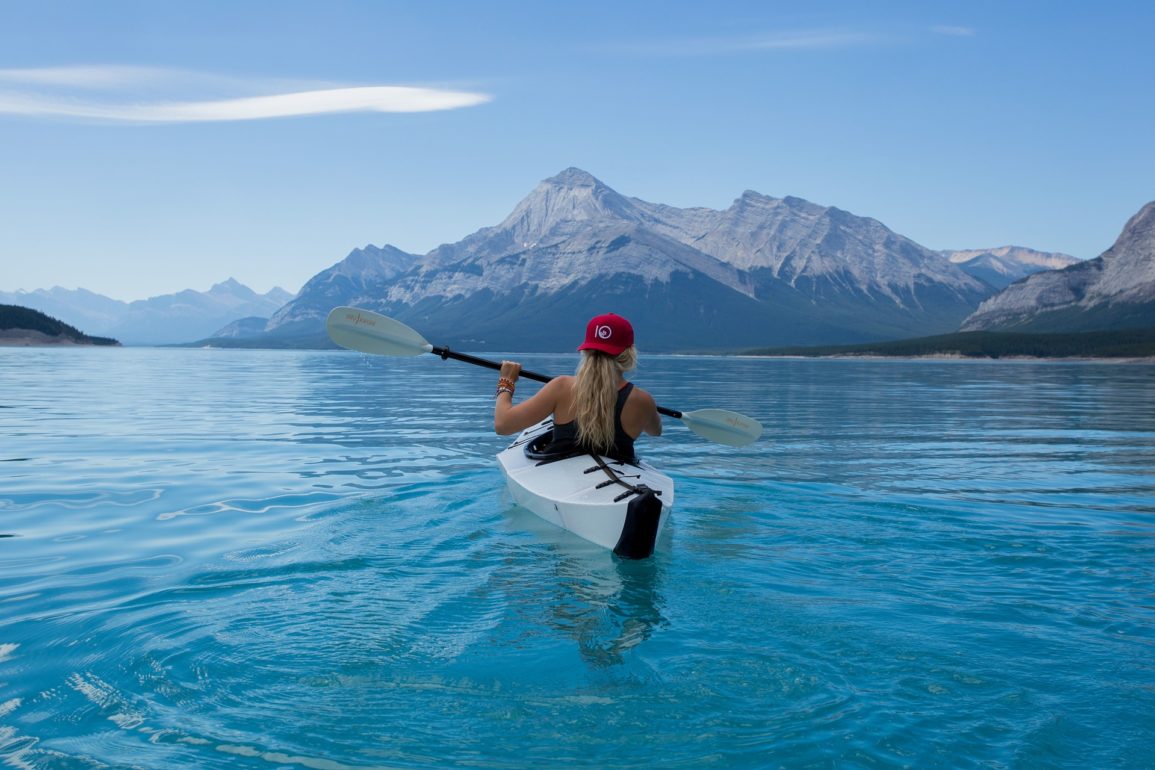 Woman rowing a kayak on a mountain lake