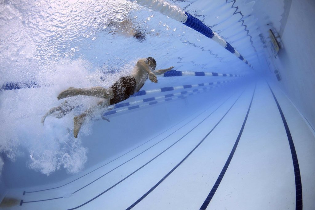 Boy swimming underwater in large pool